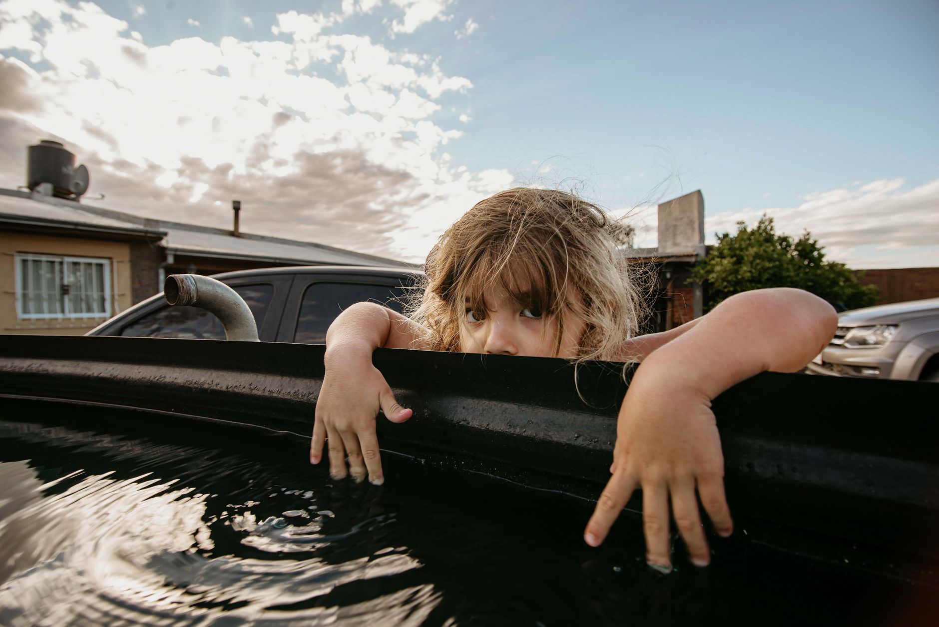Man in shorts stepping into a stainless steel cold plunge tub in a garage