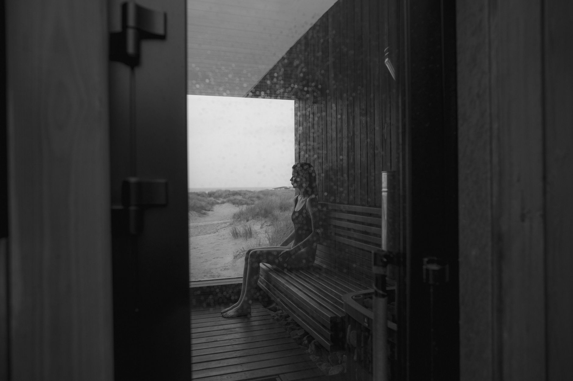 Two people sitting on wooden benches inside a hot sauna cabin