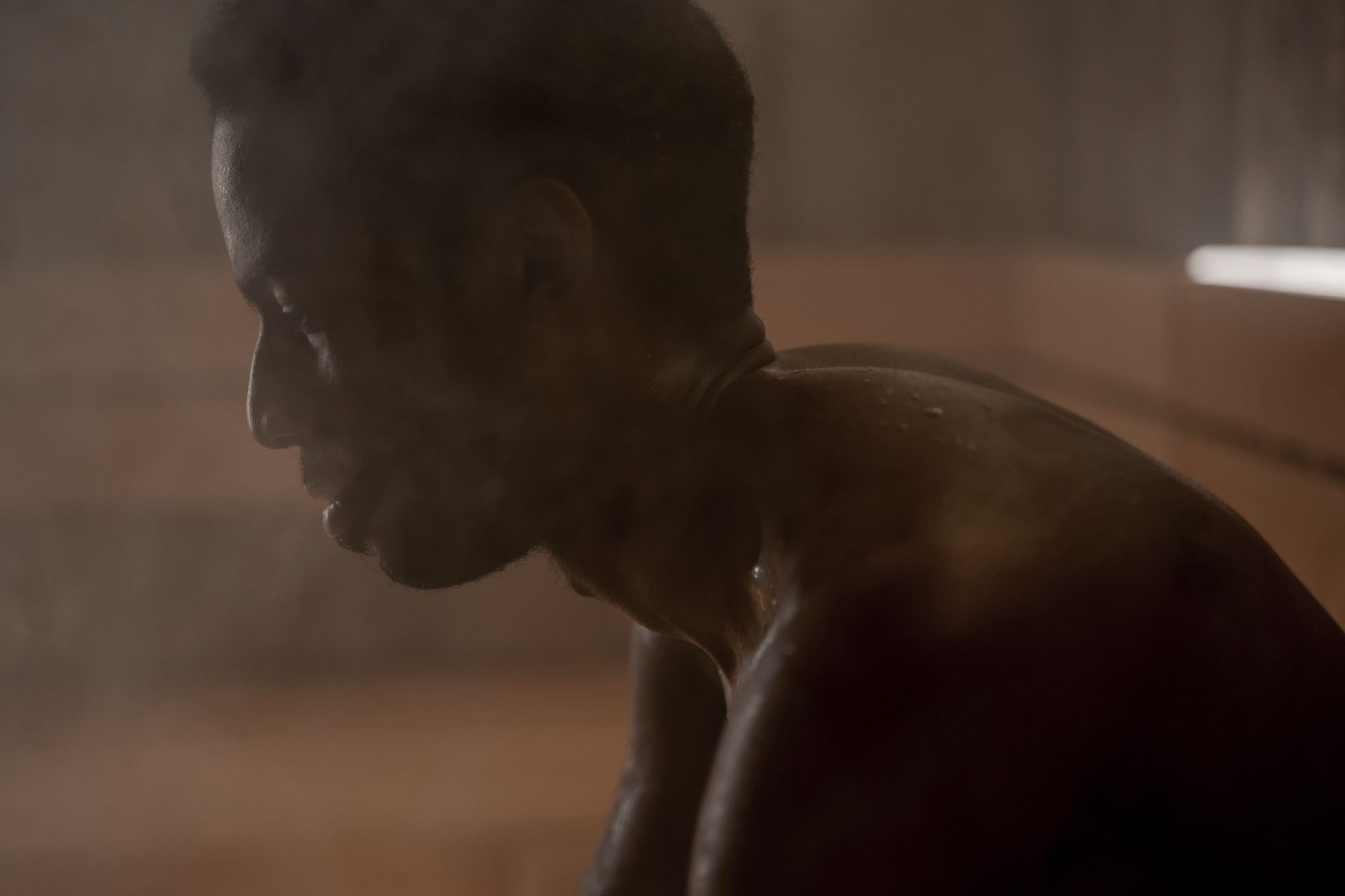 Man sitting in a traditional wooden sauna with steam rising